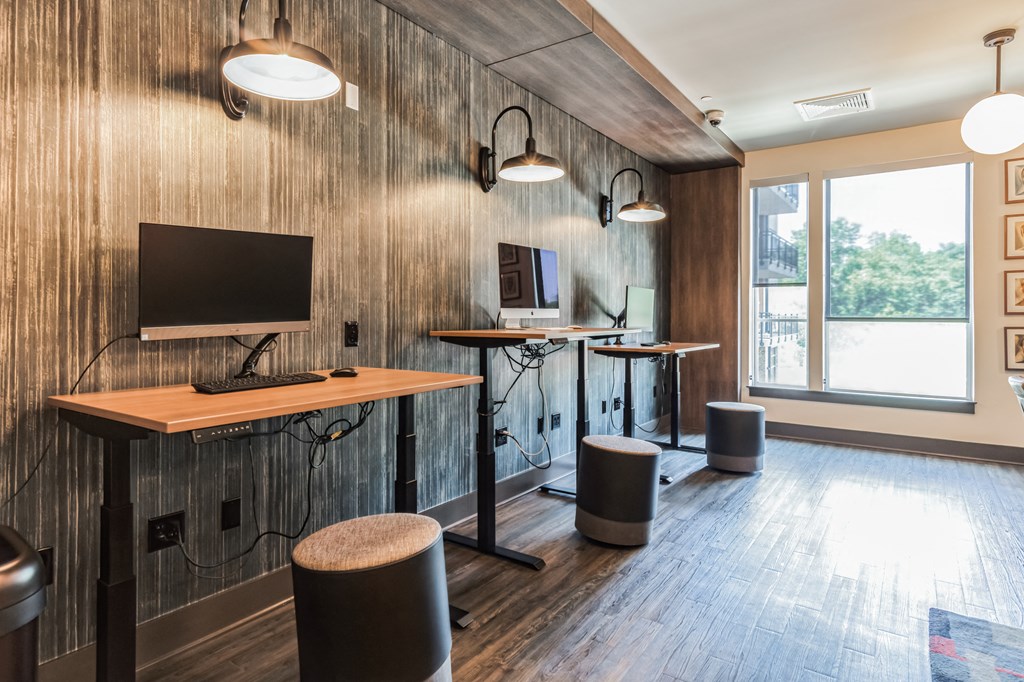 a conference room with desks and a tv in a wood accent wall