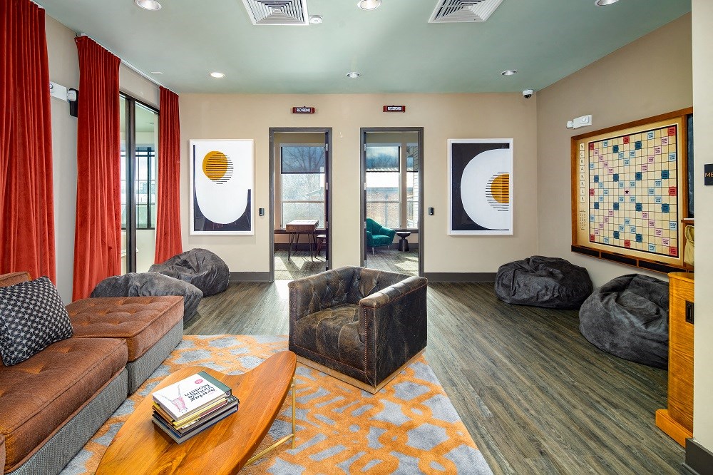 a living room with couches and chairs and a bulletin board