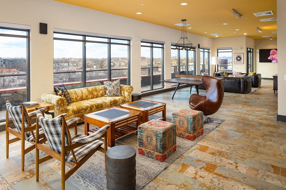 a living room with couches and chairs and a table and a large window