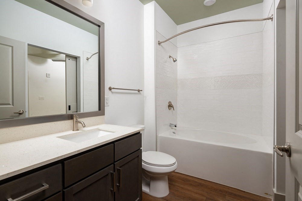 a bathroom with a shower sink and toilet and a mirror