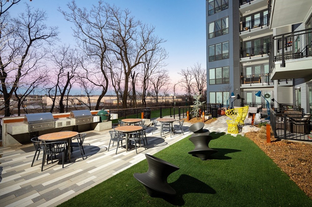 an outdoor patio with tables and chairs at an apartment building