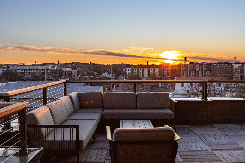 a rooftop lounge with a view of the city at sunset