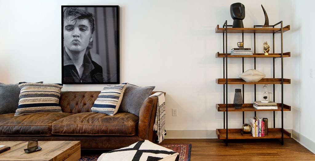 a living room with a leather couch and a black and white picture of a man