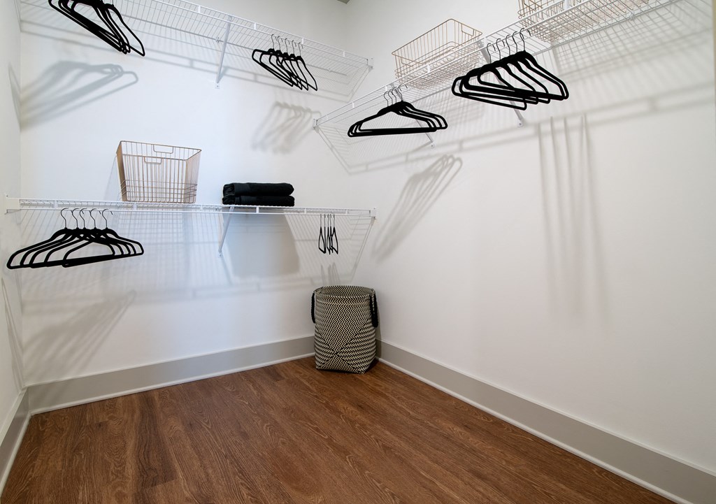 a closet with shoes hanging on the wall and a basket on the floor