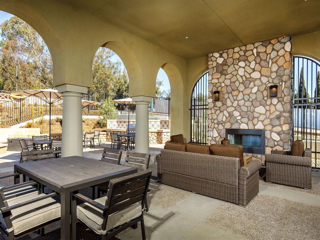 BBQ area with a fire pit, tables, couches outside
