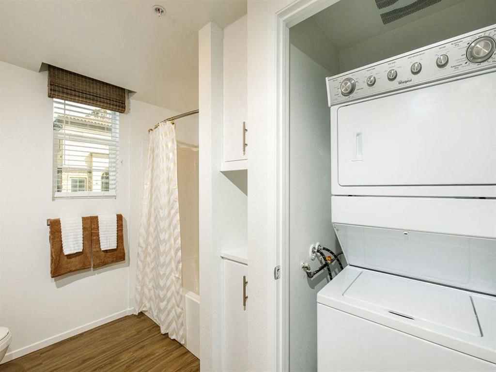 Bathroom comes with two cabinets and on the side washer and dryer with a door