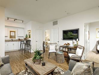 Open floor plan with spacious living room and white kitchen cabinets