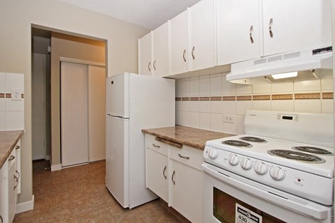 a kitchen with white appliances and white cabinets and a white refrigerator