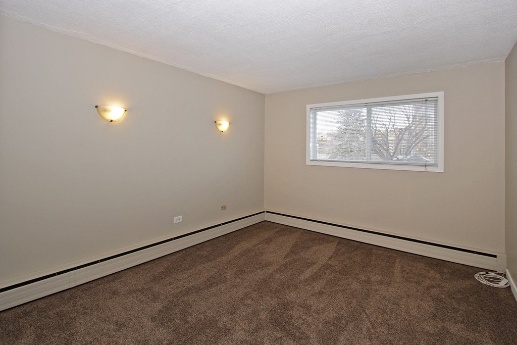 an empty room with carpet and a window