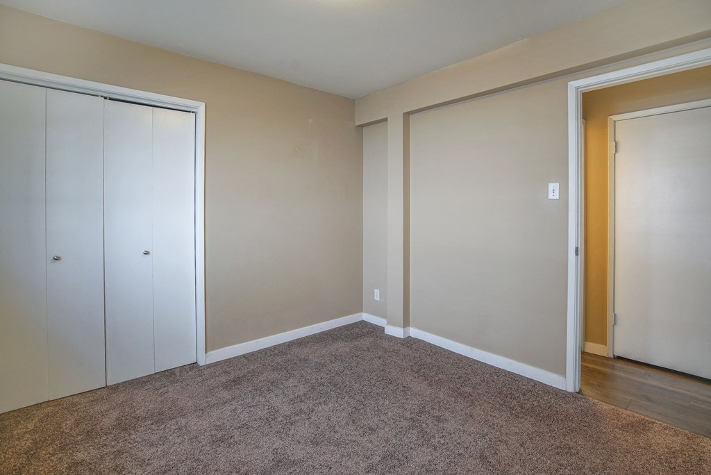 an empty room with two closets and a carpet