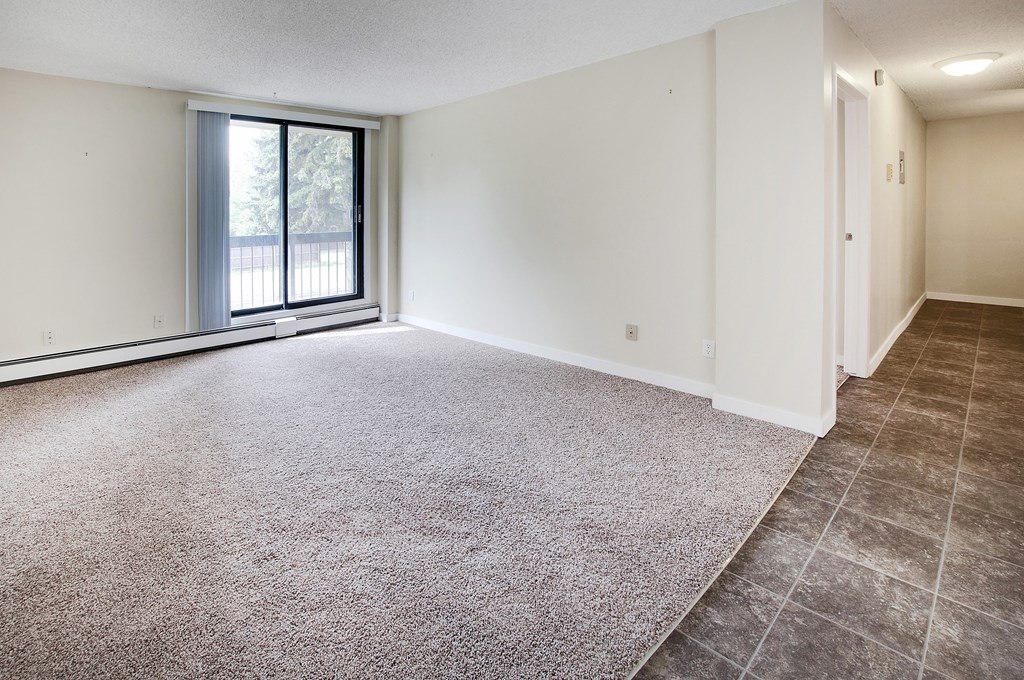 the living room and dining room of an empty home with a large window