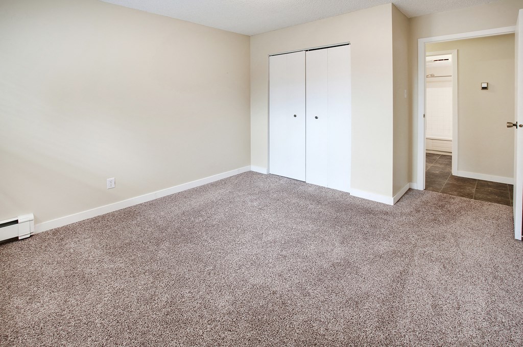 an empty living room with carpet and white walls