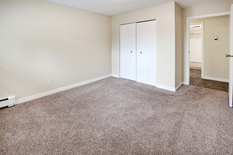 an empty living room with carpet and white walls