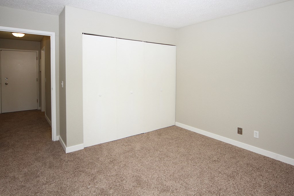 an empty room with a door to a closet
