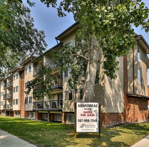 an apartment building with a for sale sign