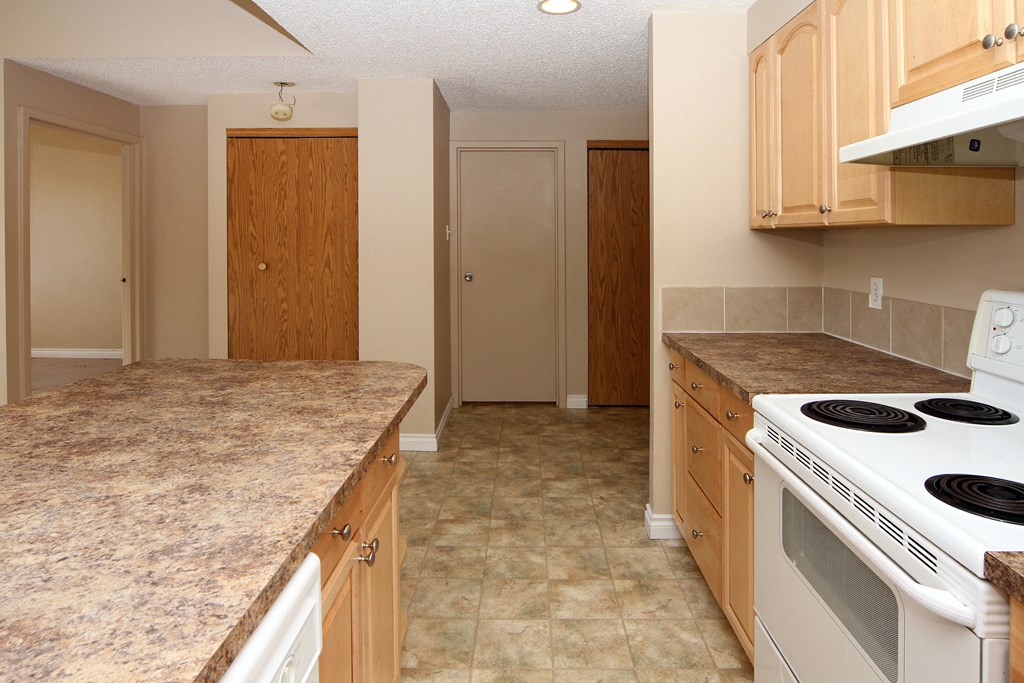 a kitchen with white appliances and granite counter tops