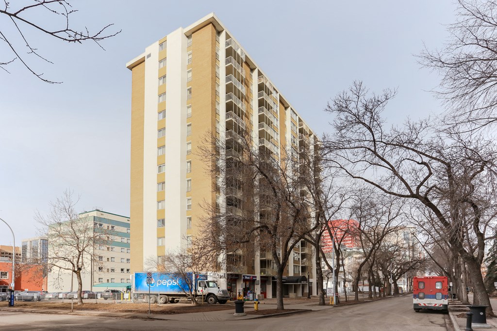 a tall building on a city street with trees