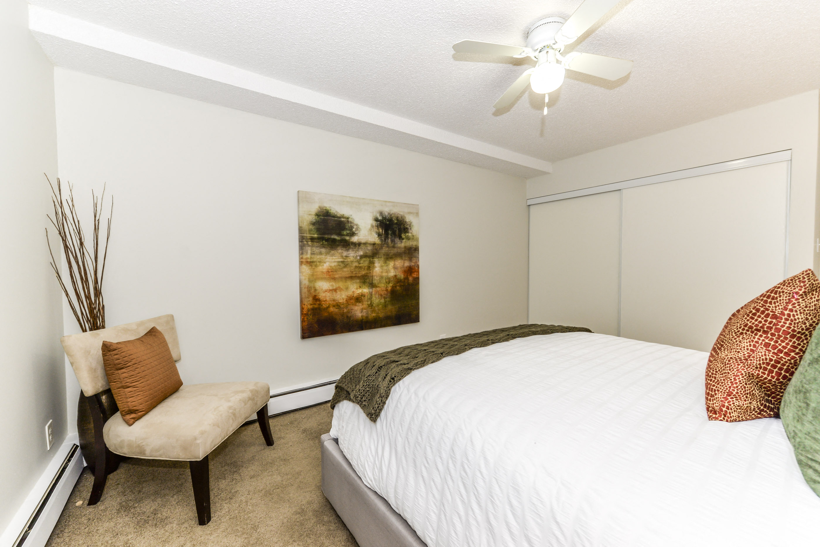 a bedroom with a bed and a ceiling fan