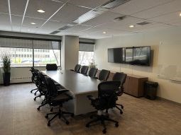A conference room with a long table and chairs.
