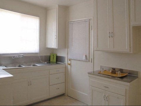 A kitchen with white cabinets and a sink.