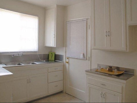 A kitchen with white cabinets and a sink.