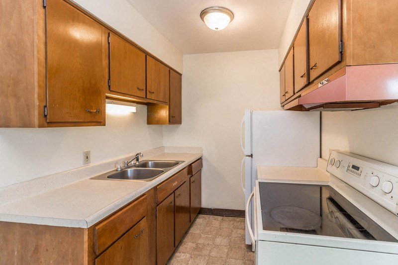 a kitchen with white appliances and wooden cabinets