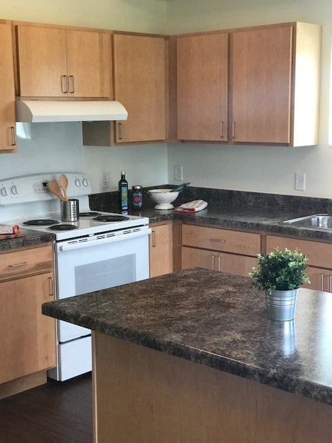 a kitchen with a marble counter top and a white stove