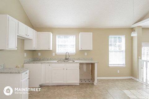 a kitchen with white cabinets and a counter top and a sink