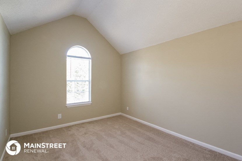 the upstairs bedroom with carpet and a large window