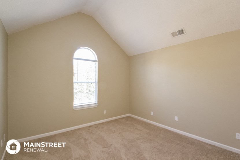 the upstairs bedroom with carpet and a window