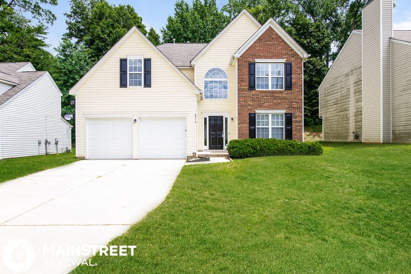 a white house with a yard and a white driveway