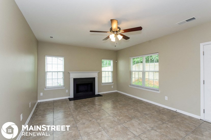 a living room with a fireplace and a ceiling fan