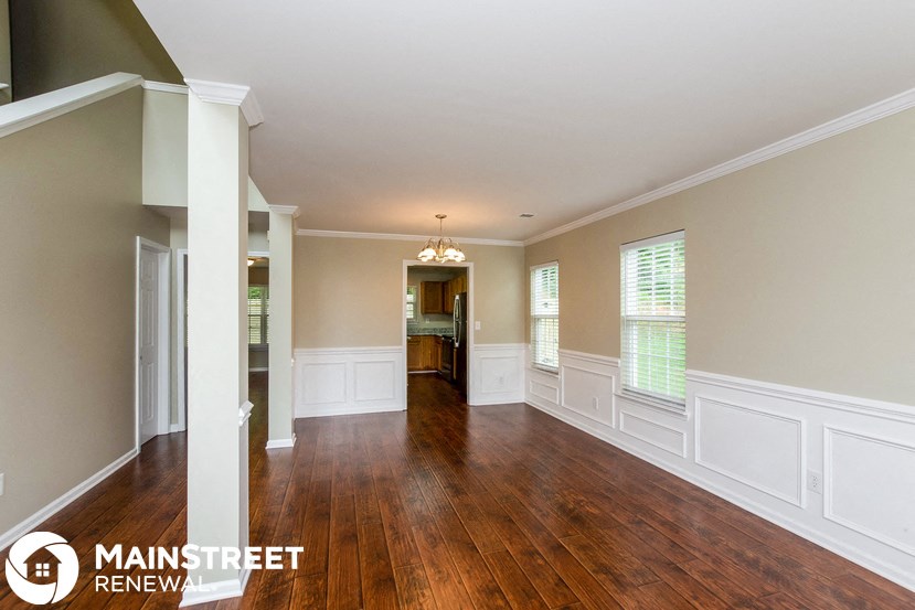 an empty living room with wood floors and white walls
