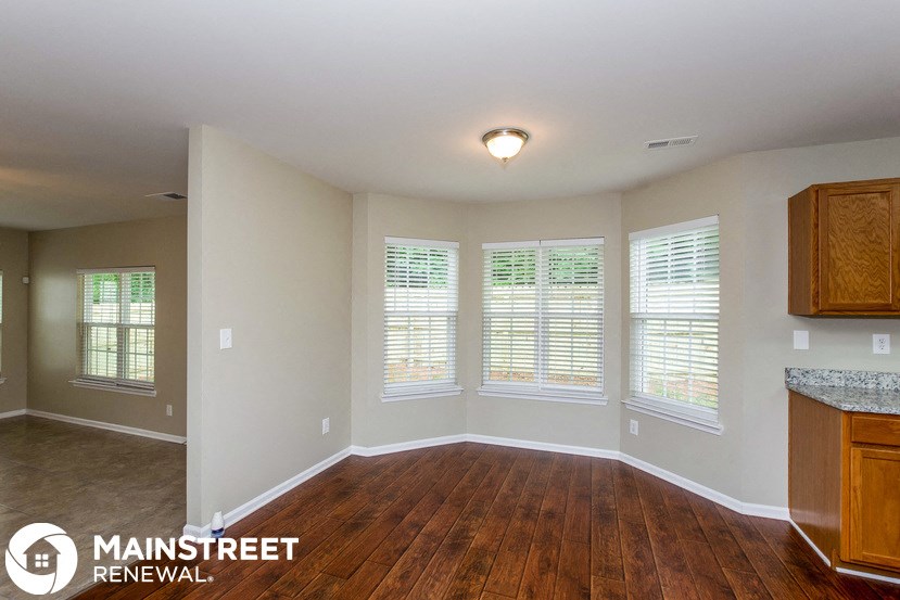 a living room with wood floors and a large window