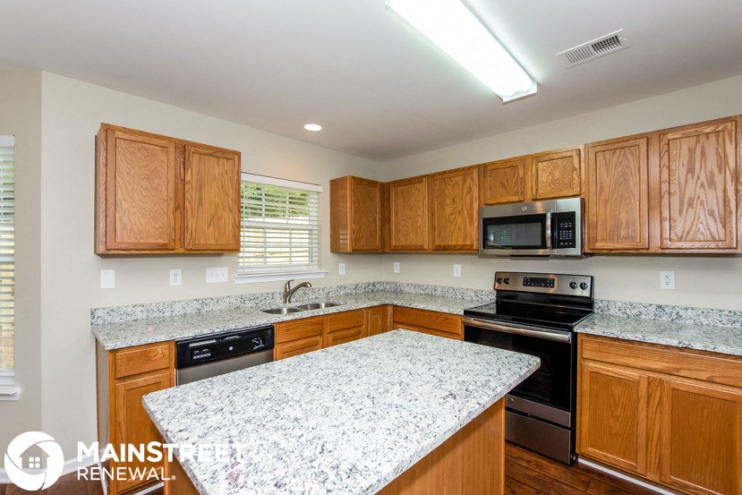 a kitchen with wooden cabinets and granite counter tops and black appliances