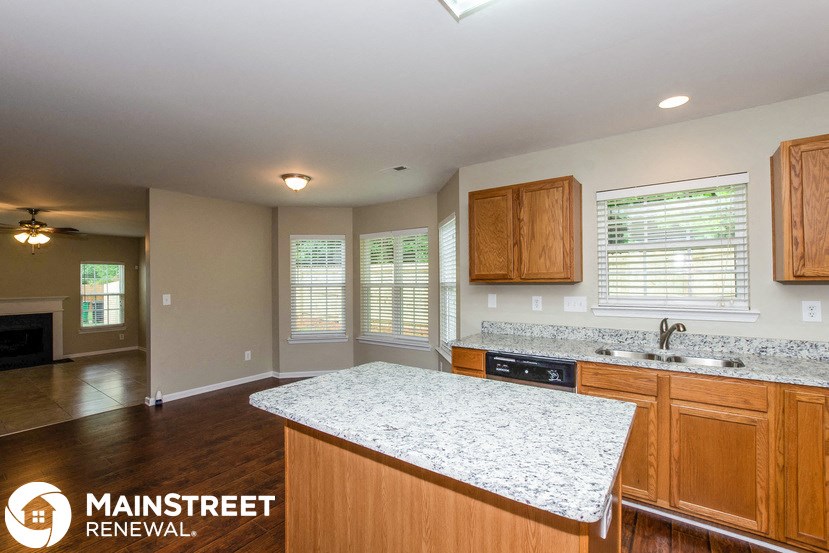 a kitchen with a marble counter top and wooden cabinets