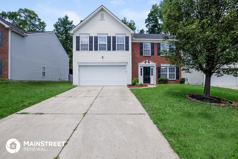 a white house with a white garage door and a driveway