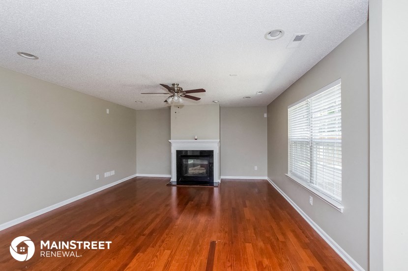 the living room with wood flooring and a fireplace