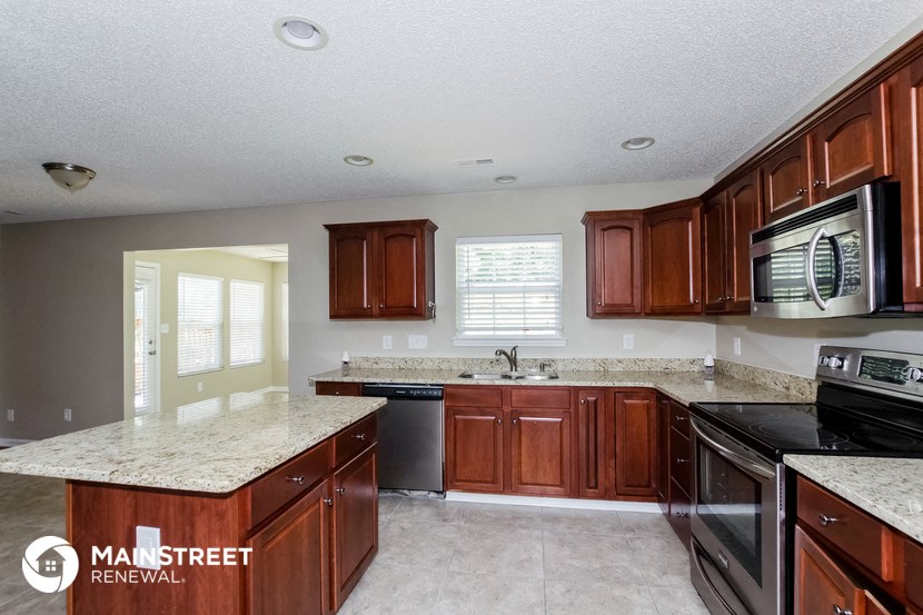 a kitchen with granite counter tops and wooden cabinets