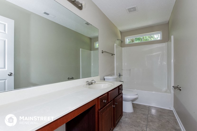 a bathroom with a large mirror and a sink and a toilet