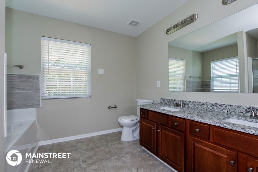 a bathroom with a toilet and a sink and a mirror