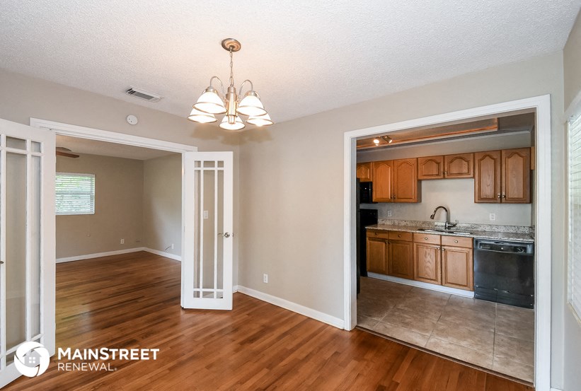 the living room and dining room with the kitchen in the background