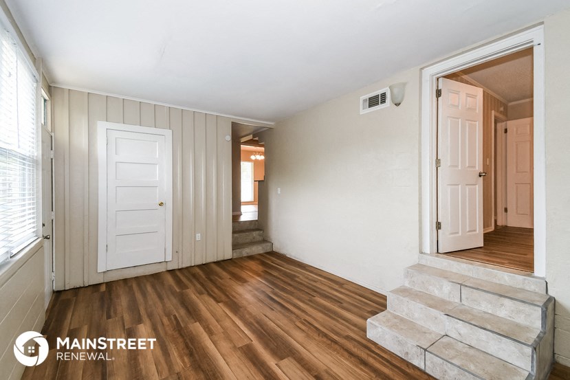 the entryway of a home with stairs and a white door