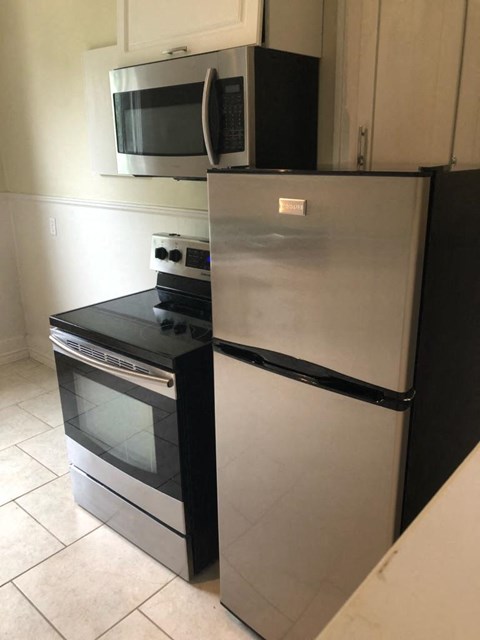 a stainless steel refrigerator and a microwave in a kitchen