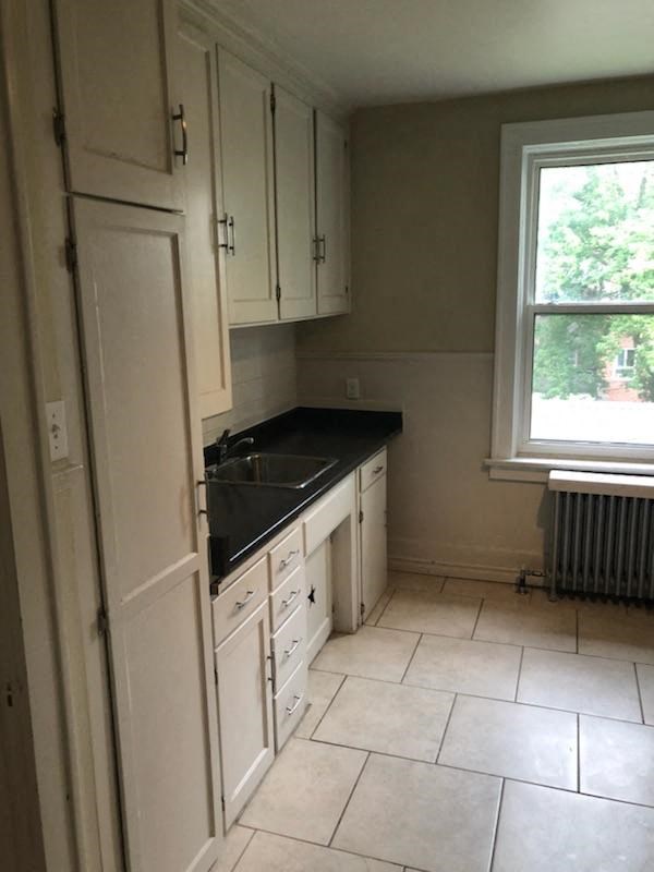 a small kitchen with white cabinets and a sink
