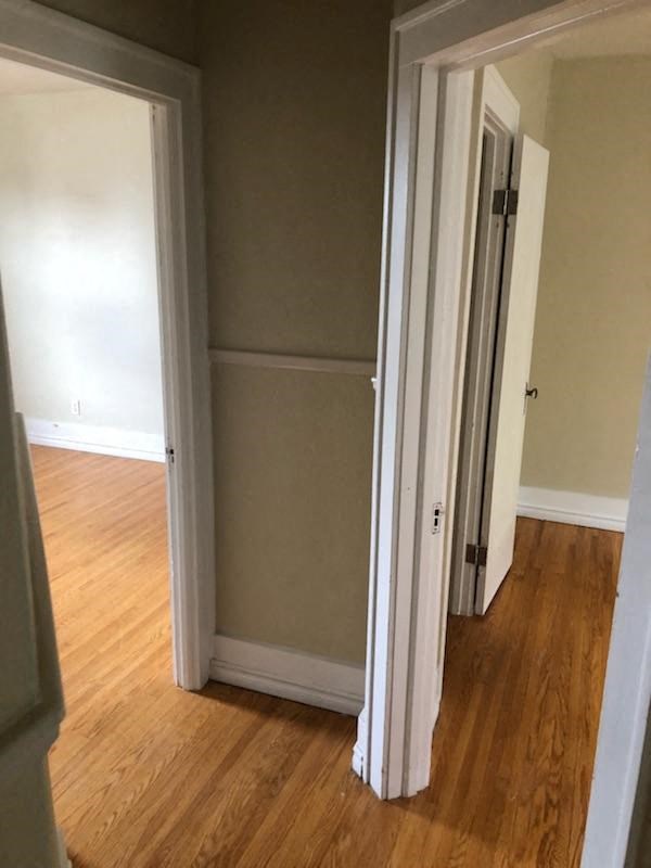 a room with an open door and a wood floor