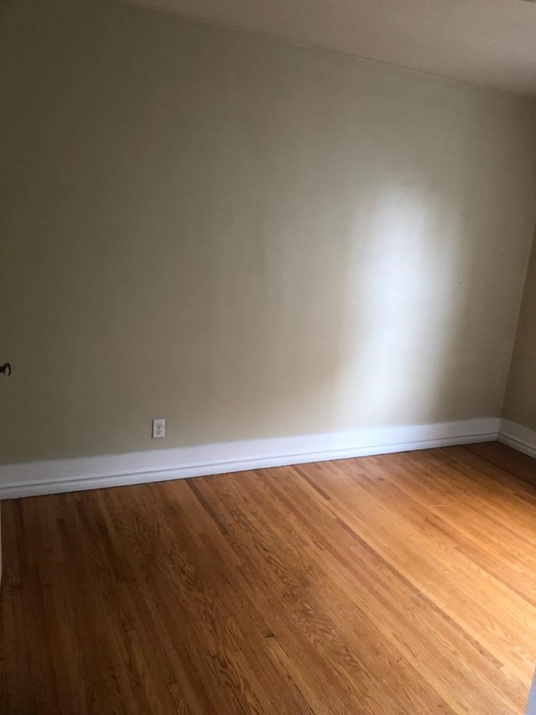 an empty room with wooden floors and white walls