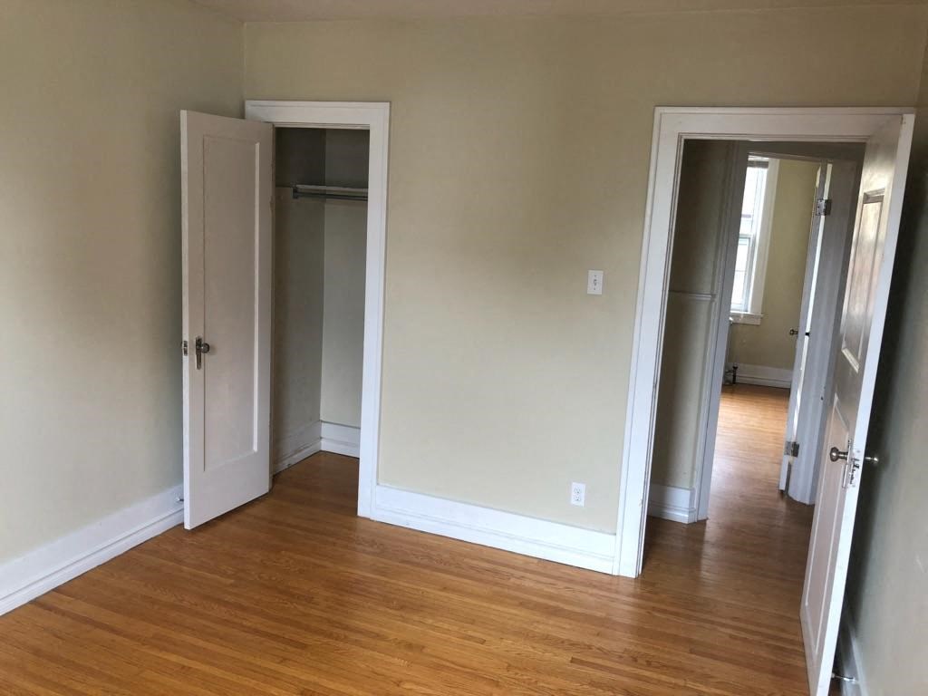 an empty room with a wood floor and a closet