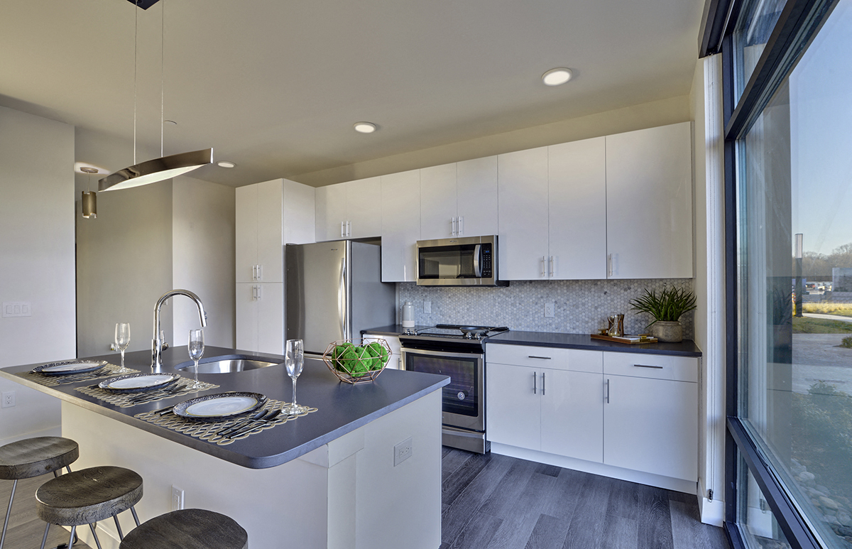A modern kitchen with white cabinets and a large island.