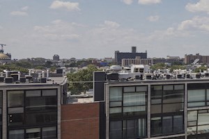 a rendering of a building with a swimming pool and a city in the background